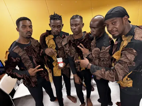 Groupe de musiciens en tenues assorties présentant les créations MAYAY