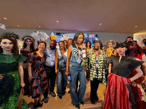 Groupe de participants en tenues colorées réunis lors d’une exposition