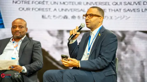 Intervenant au microphone lors d’une conférence sur la forêt gabonaise à Osaka