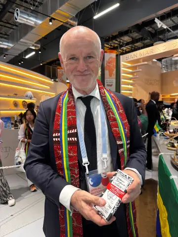 Participant présentant un chocolat à l’iboga lors d’un salon