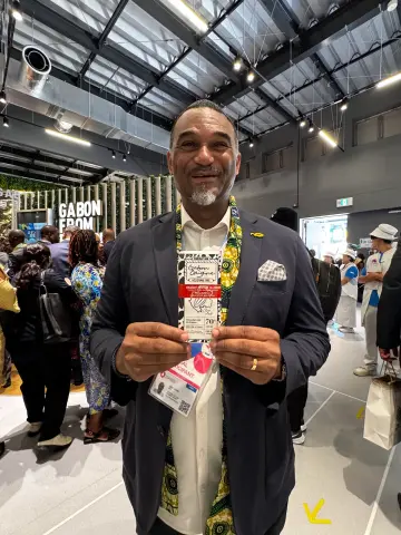 Participant tenant une création MAYAY au milieu des stands